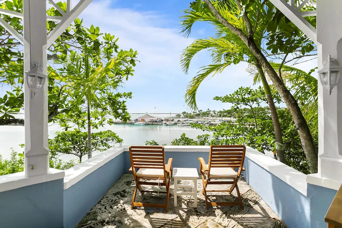 Covered balcony with wooden chairs facing the harbour
