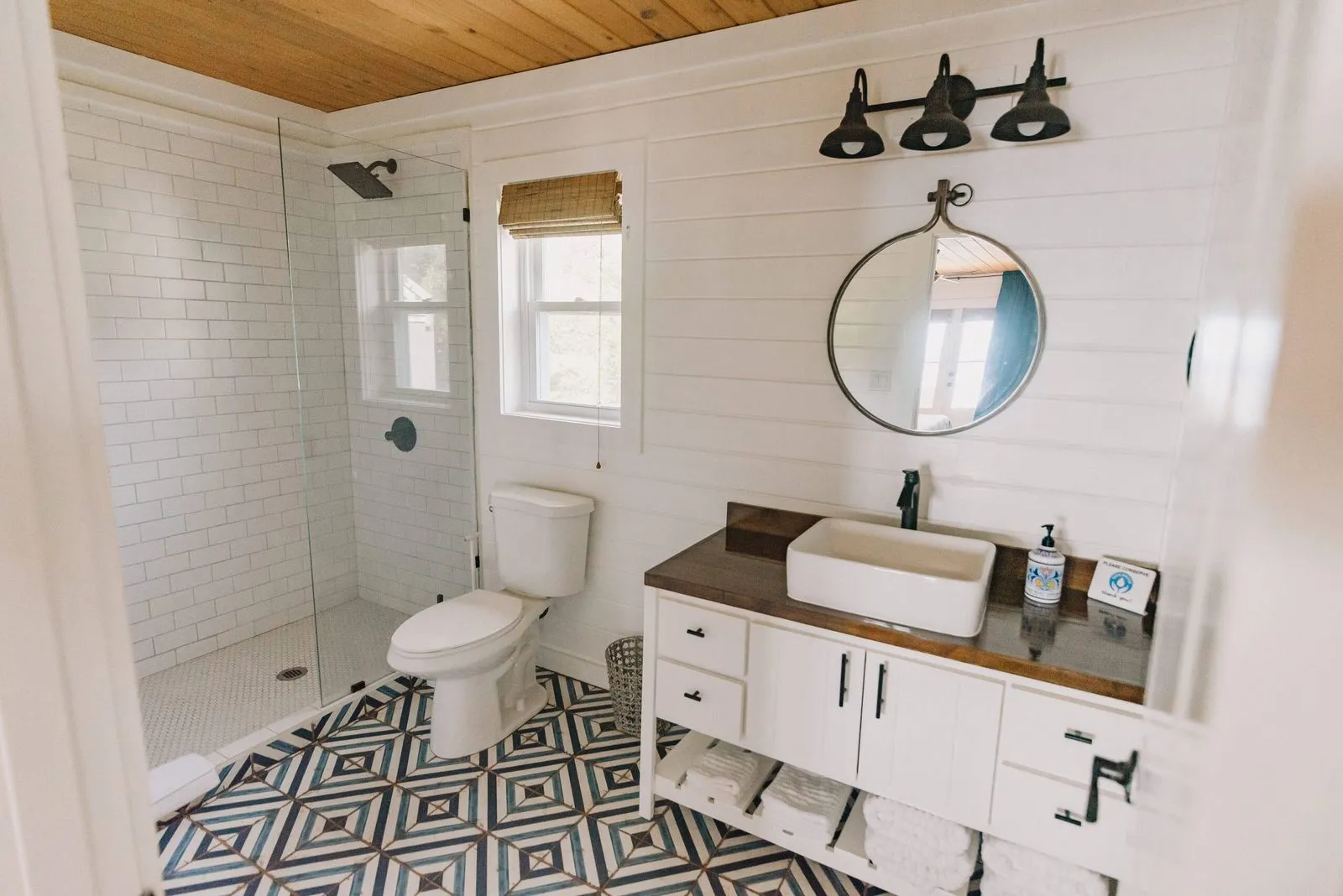 Bathroom with patterned tile floor and glass shower
