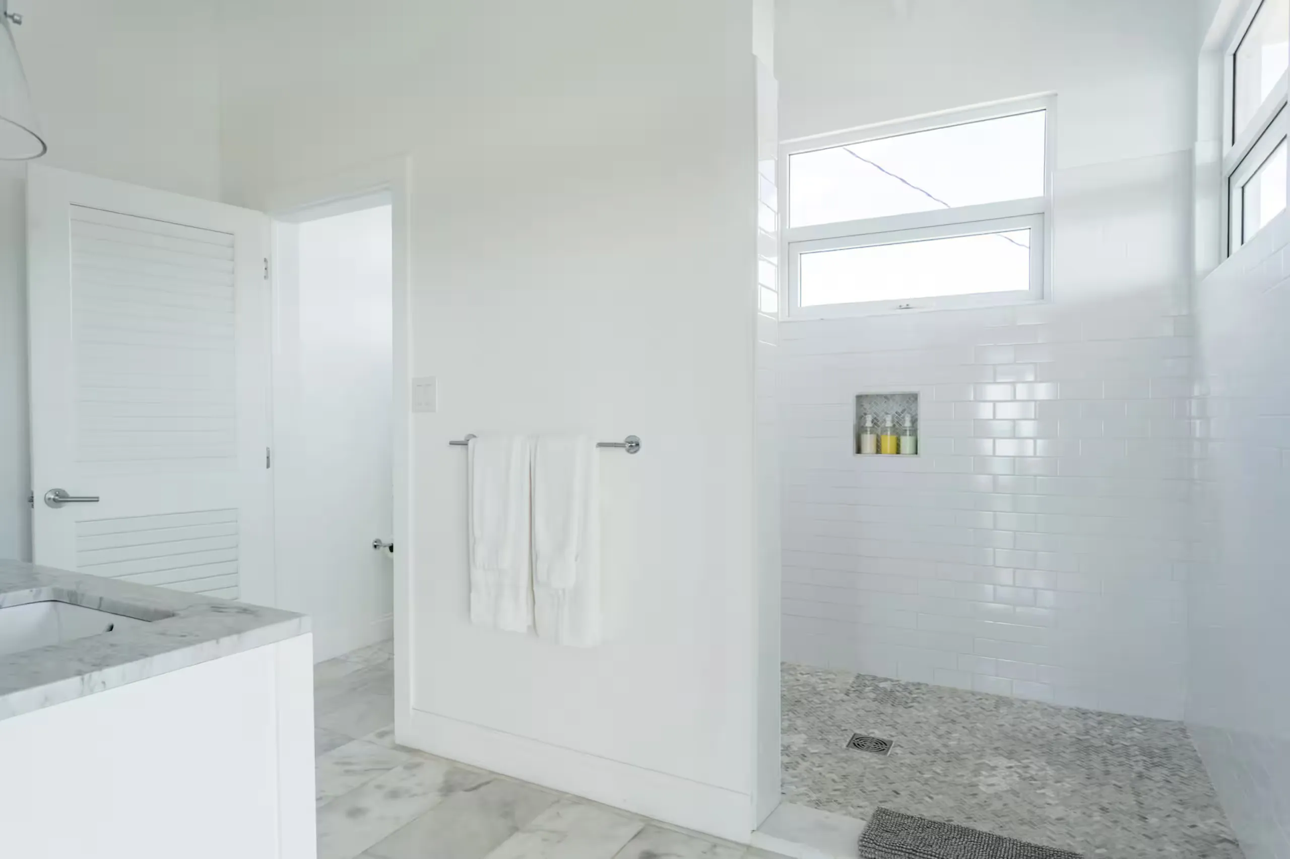 Bathroom with a marble vanity and walk-in tiled shower
