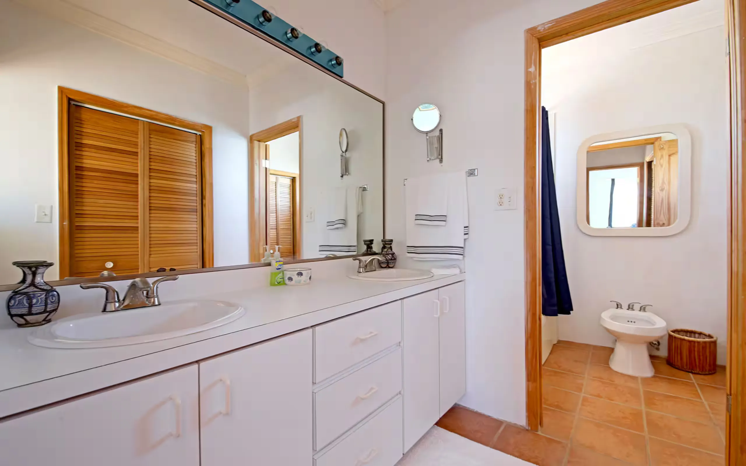 Bathroom with double vanity and separate toilet room