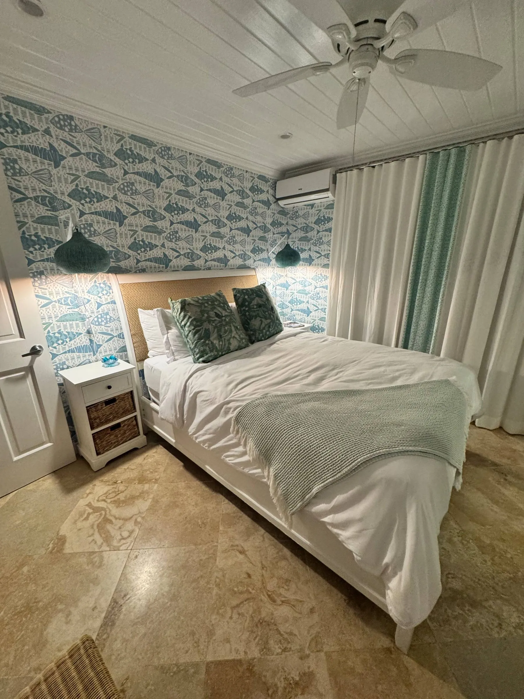 Bedroom with fish-print wallpaper and a woven headboard