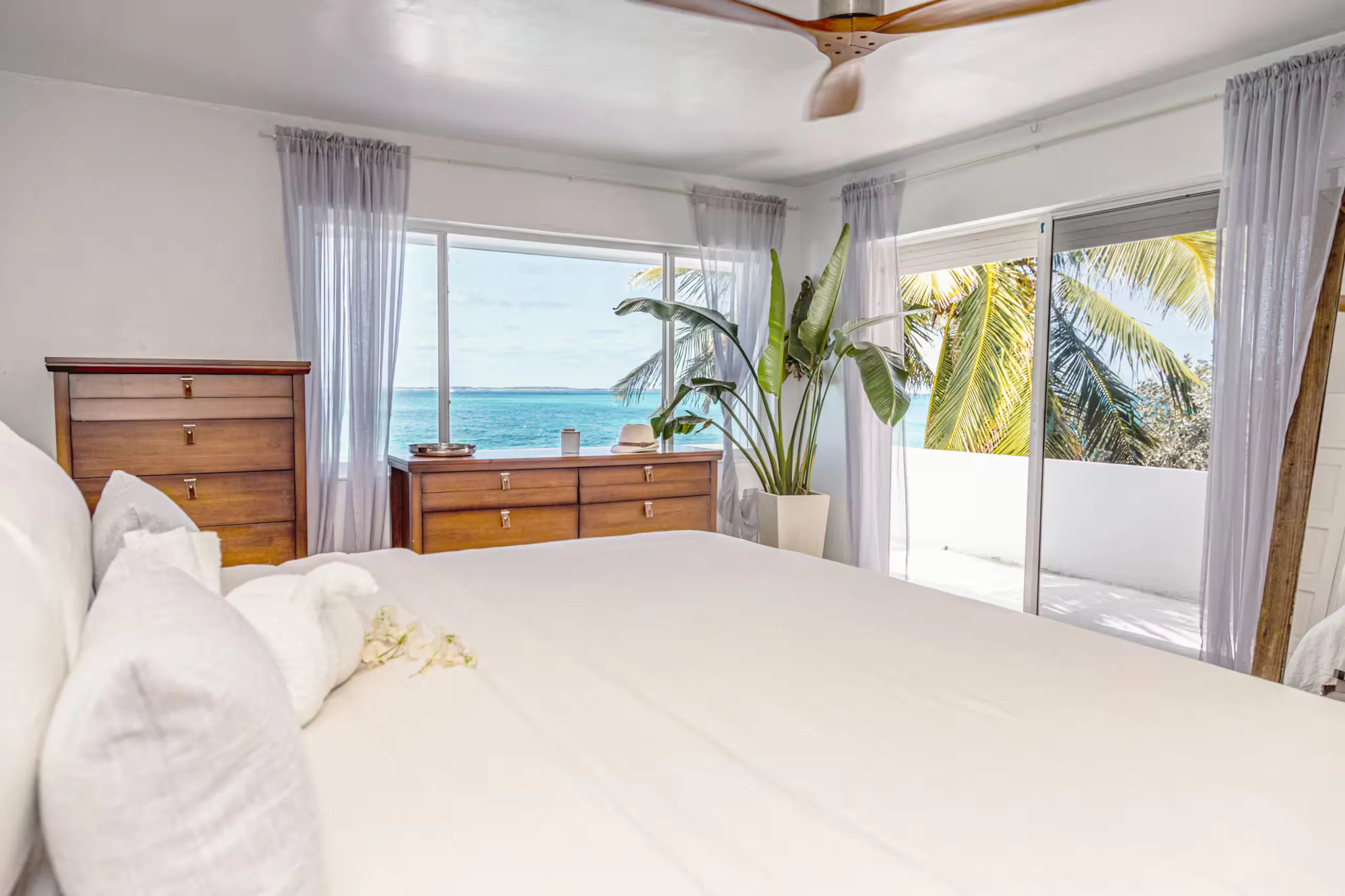 Bedroom opening onto a palm-lined terrace