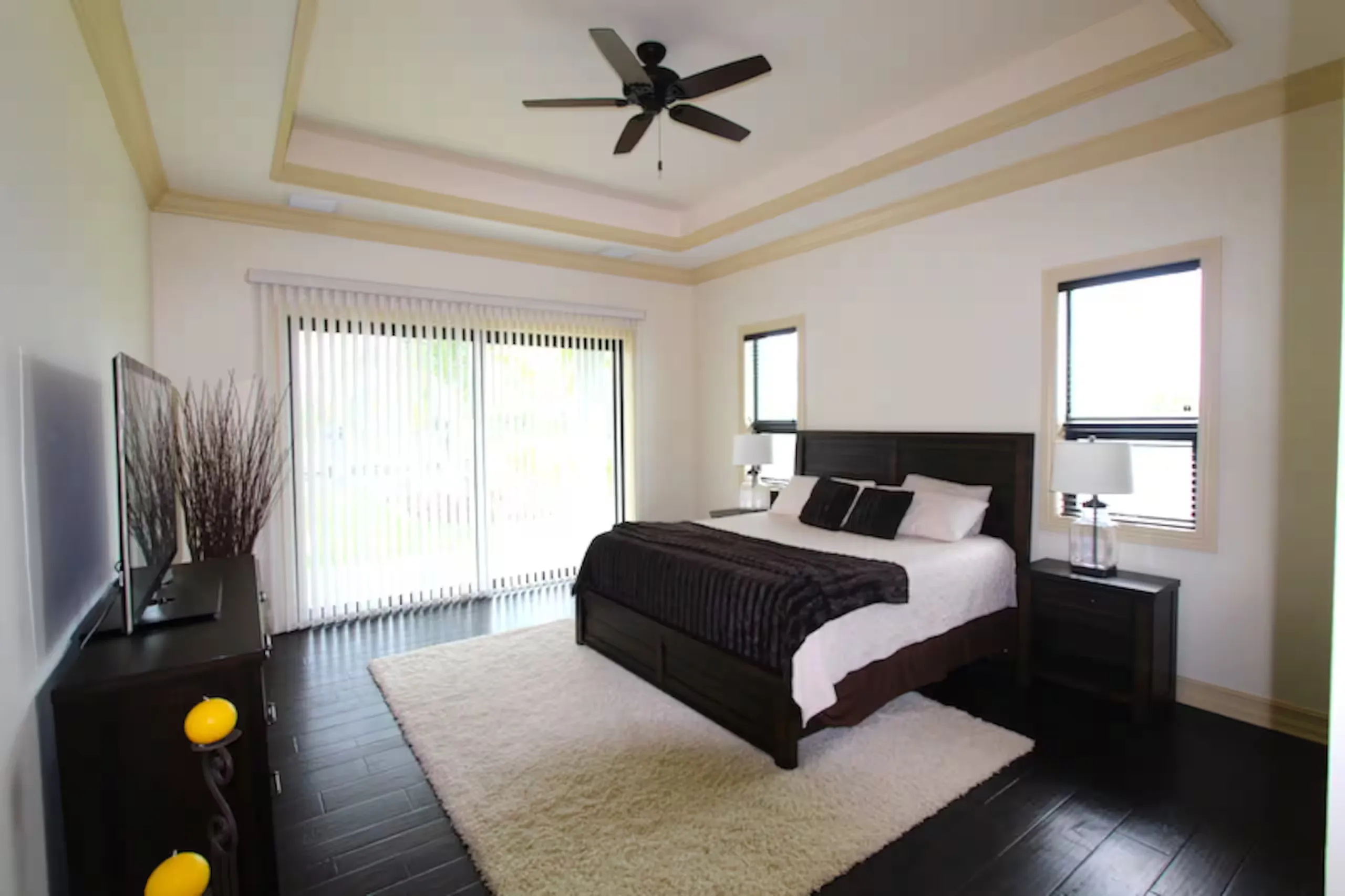 Bedroom suite with a tray ceiling and dark wood furniture