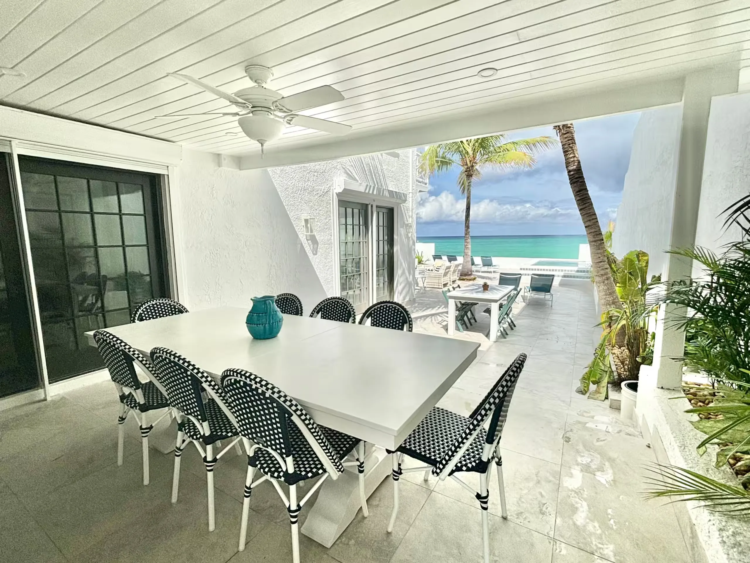 Covered patio dining table looking out to turquoise water