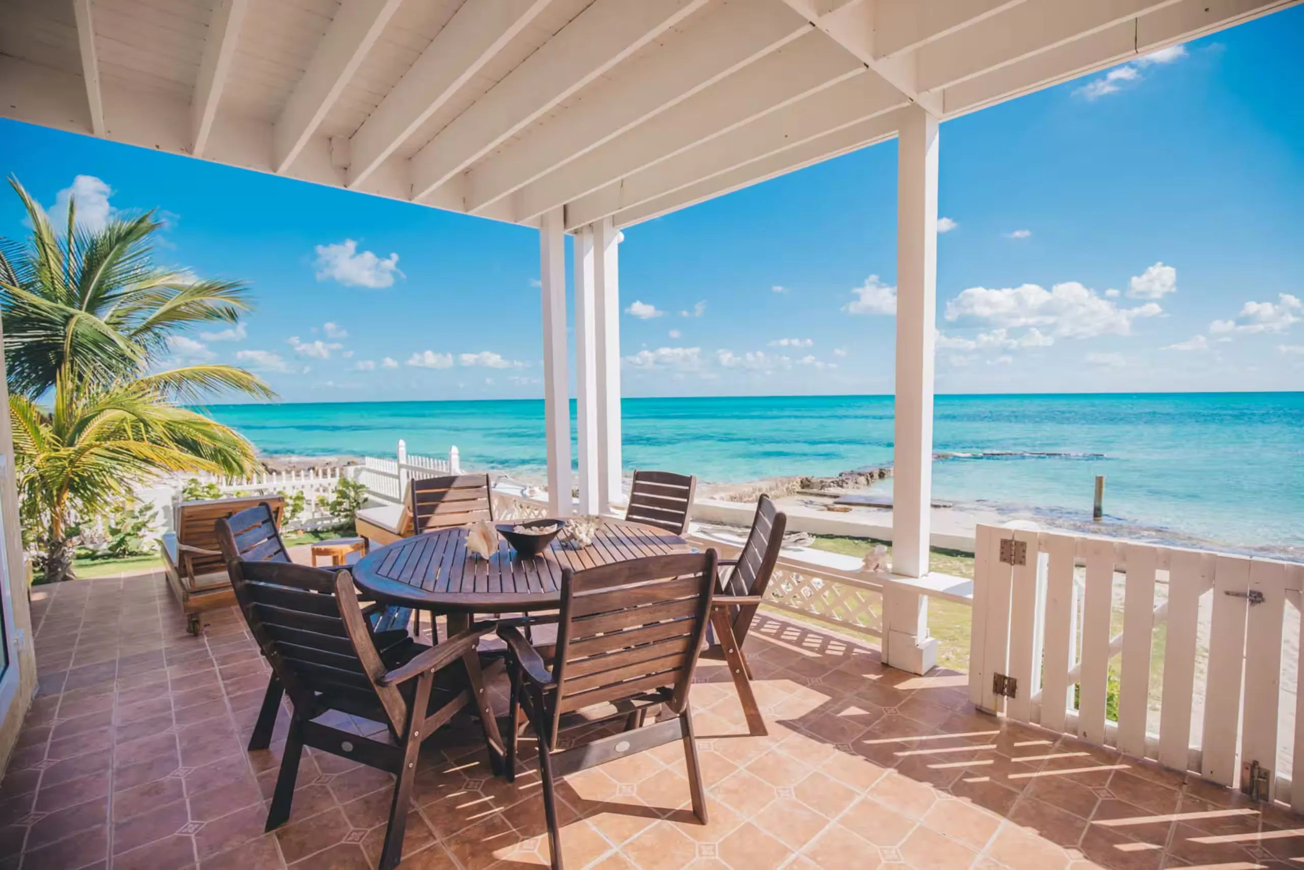 Covered patio dining area facing the water