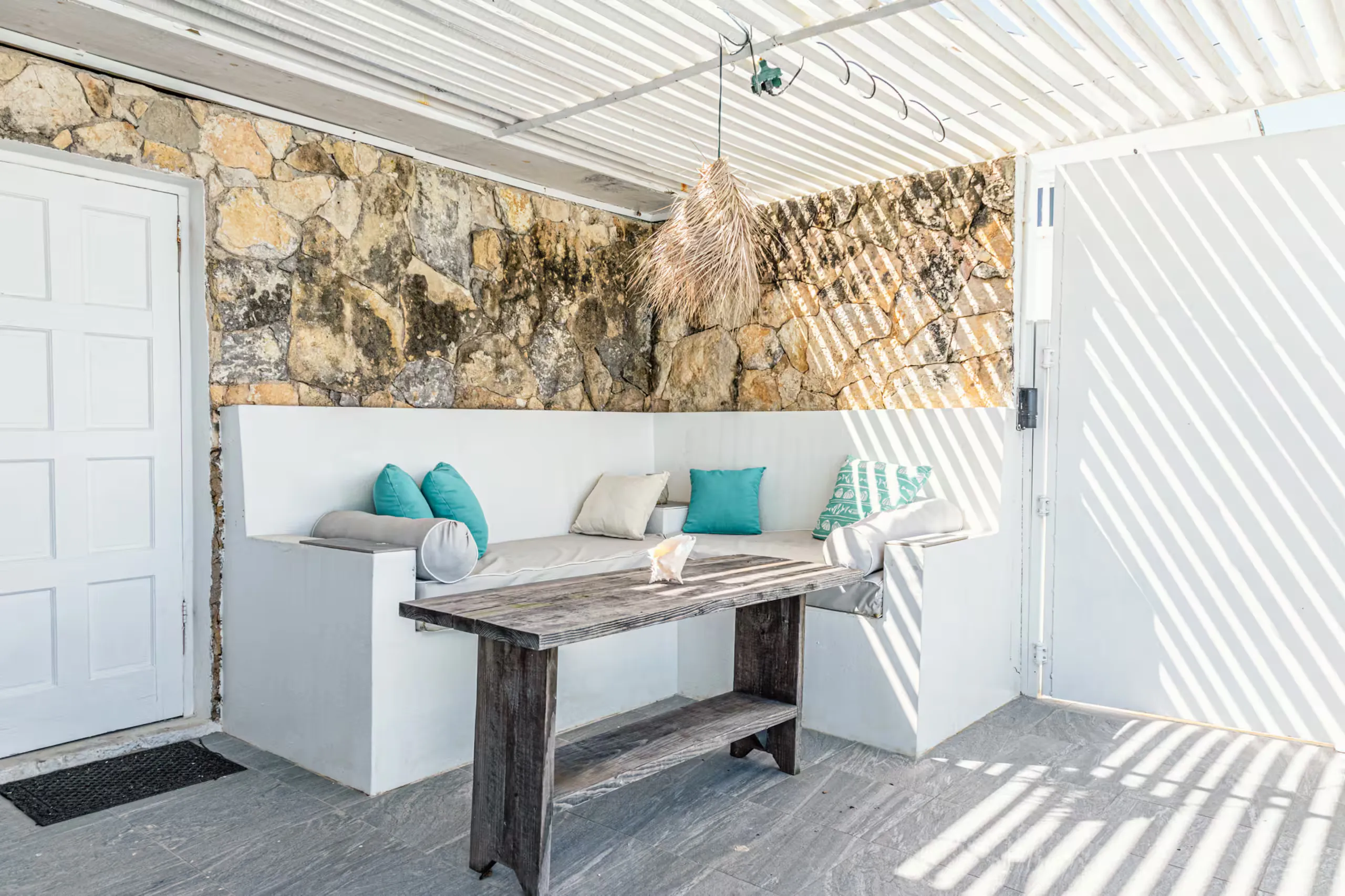 Covered stone patio nook with built-in bench seating
