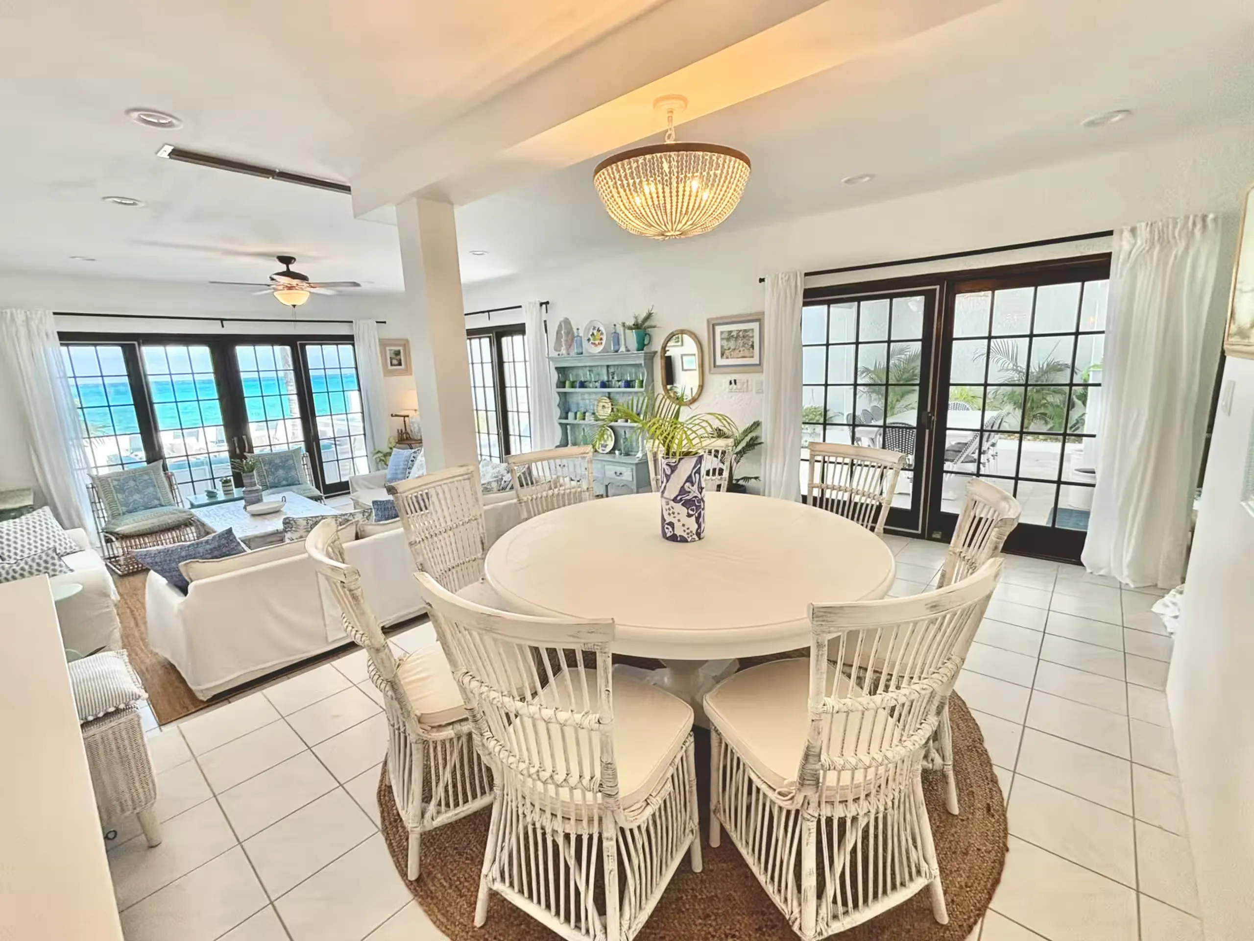Dining table and living area with glass doors facing the ocean