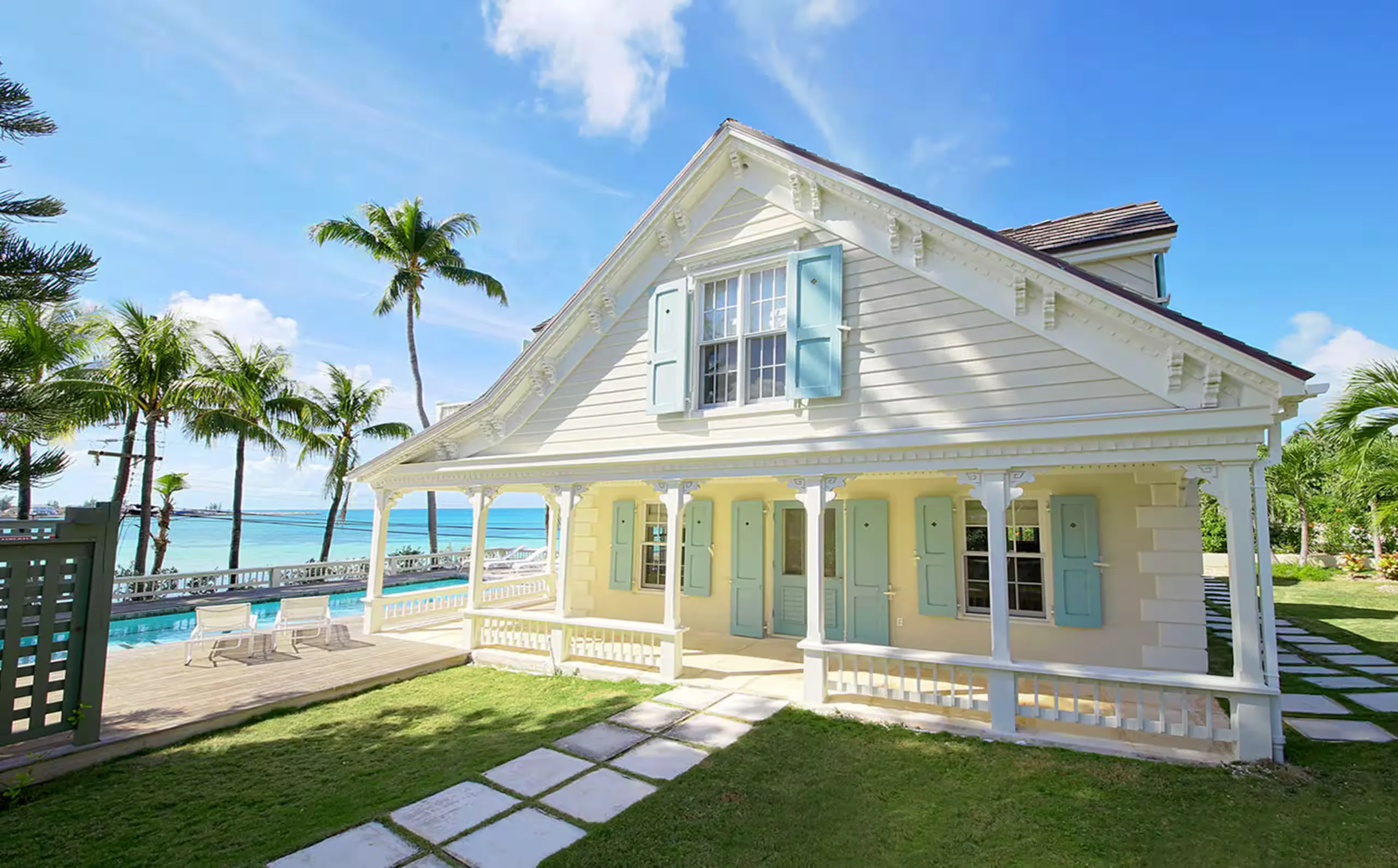 Front porch and pool with pastel shutters and ocean beyond