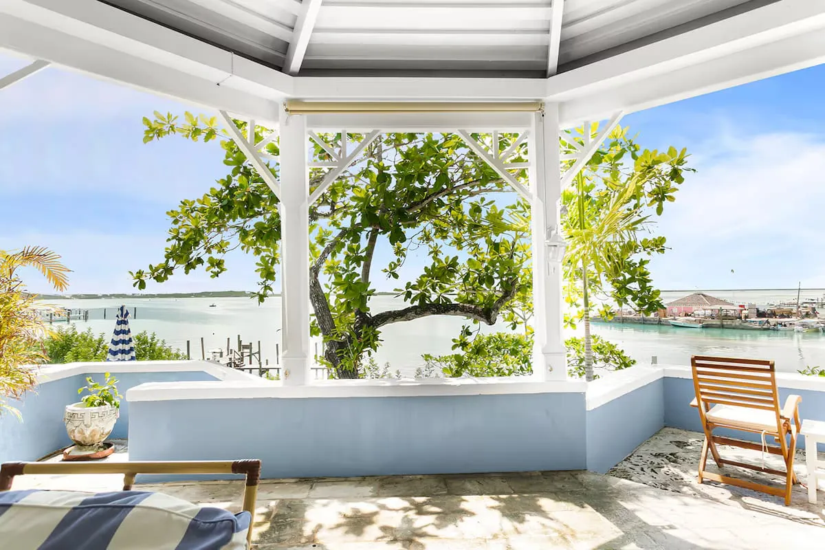Gazebo seating looking through tropical foliage to the harbour