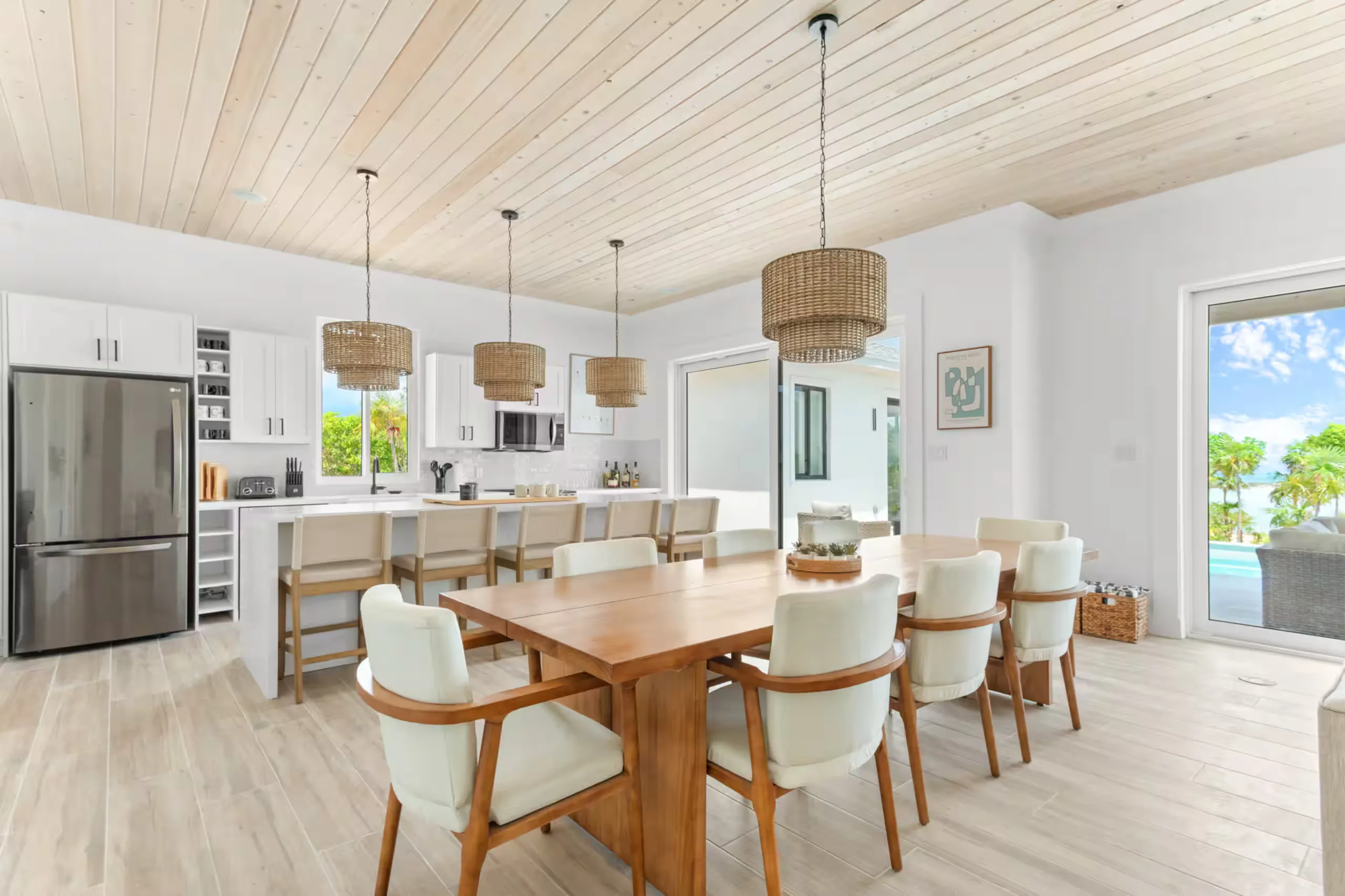 Open kitchen and dining area with rattan pendants and pool views