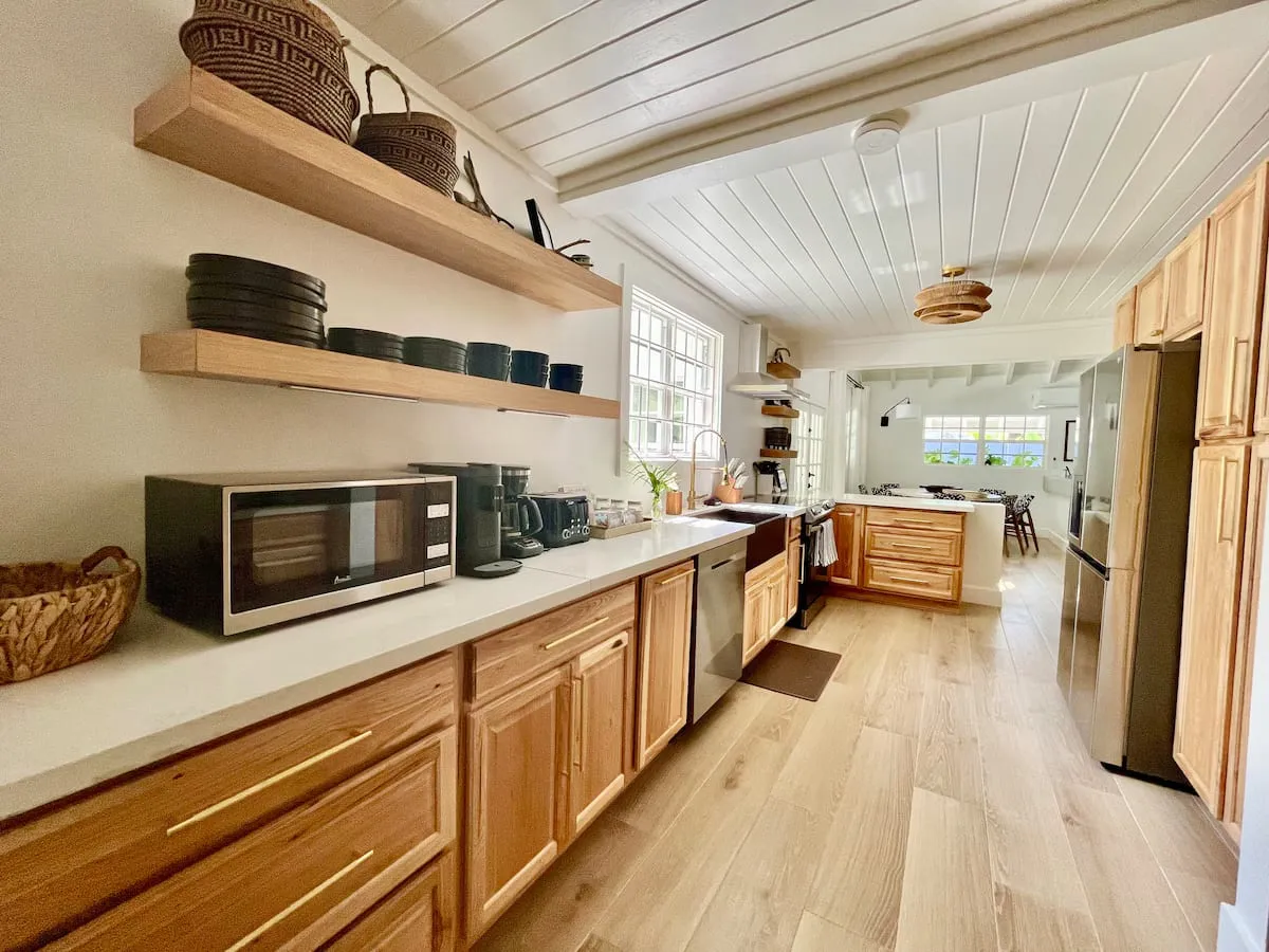 Full kitchen with light wood cabinets, white counters, and stainless appliances