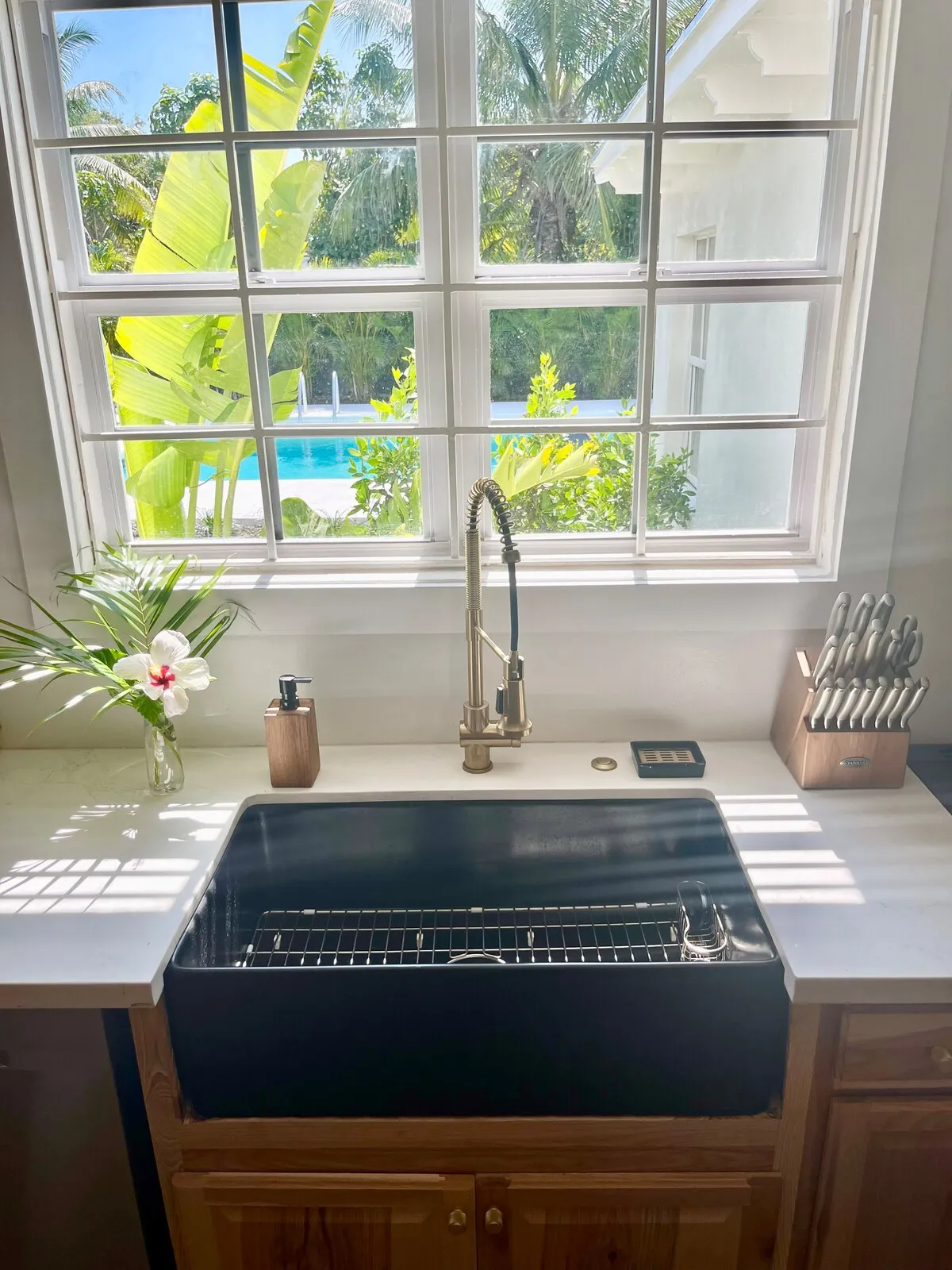 Kitchen farmhouse sink under a window looking out to the private pool