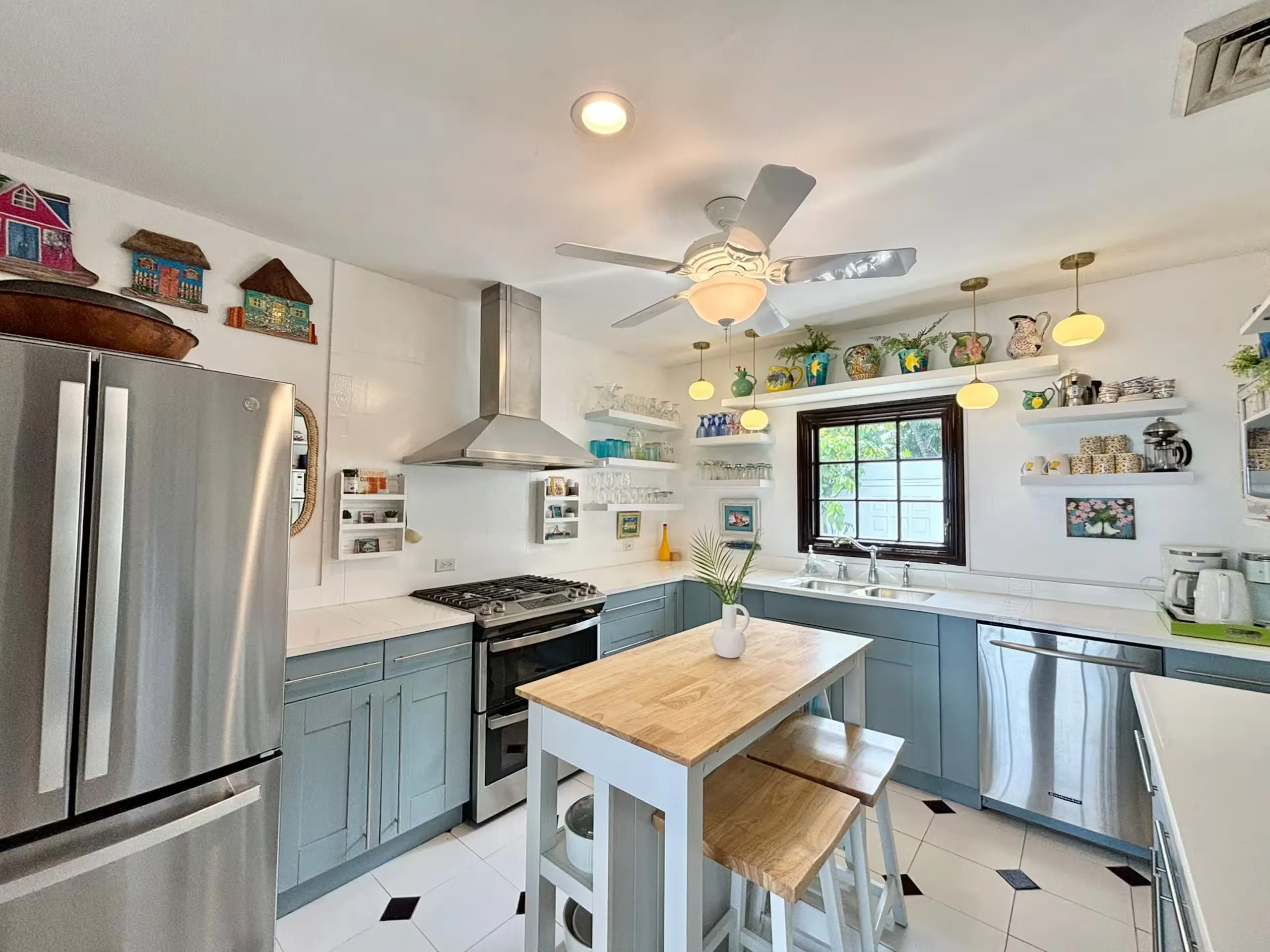 Kitchen with light blue cabinets, a wood island, and open shelving