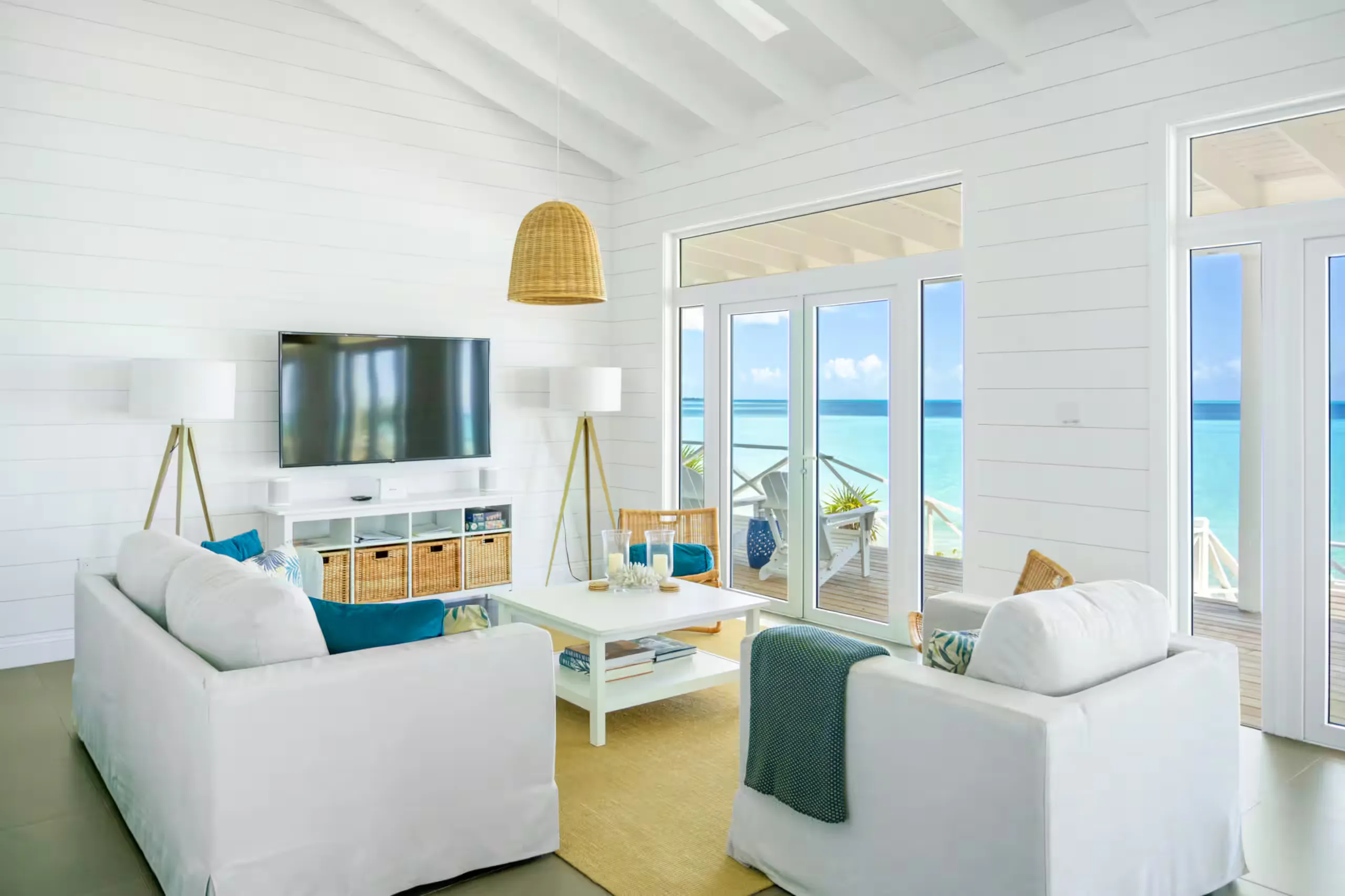 Living room opening onto the deck and ocean through glass doors