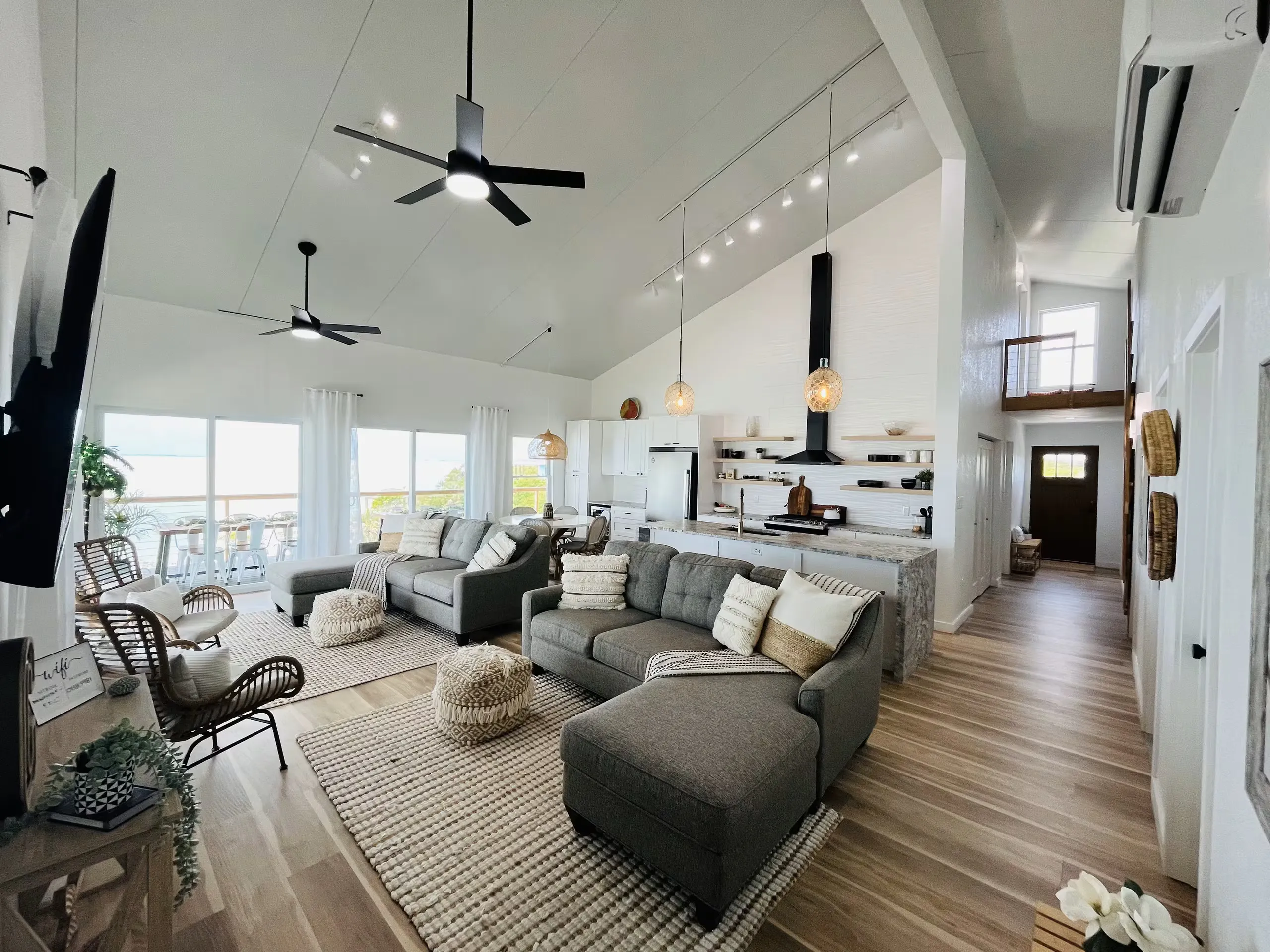 Open-plan living room with vaulted ceilings and a hallway view