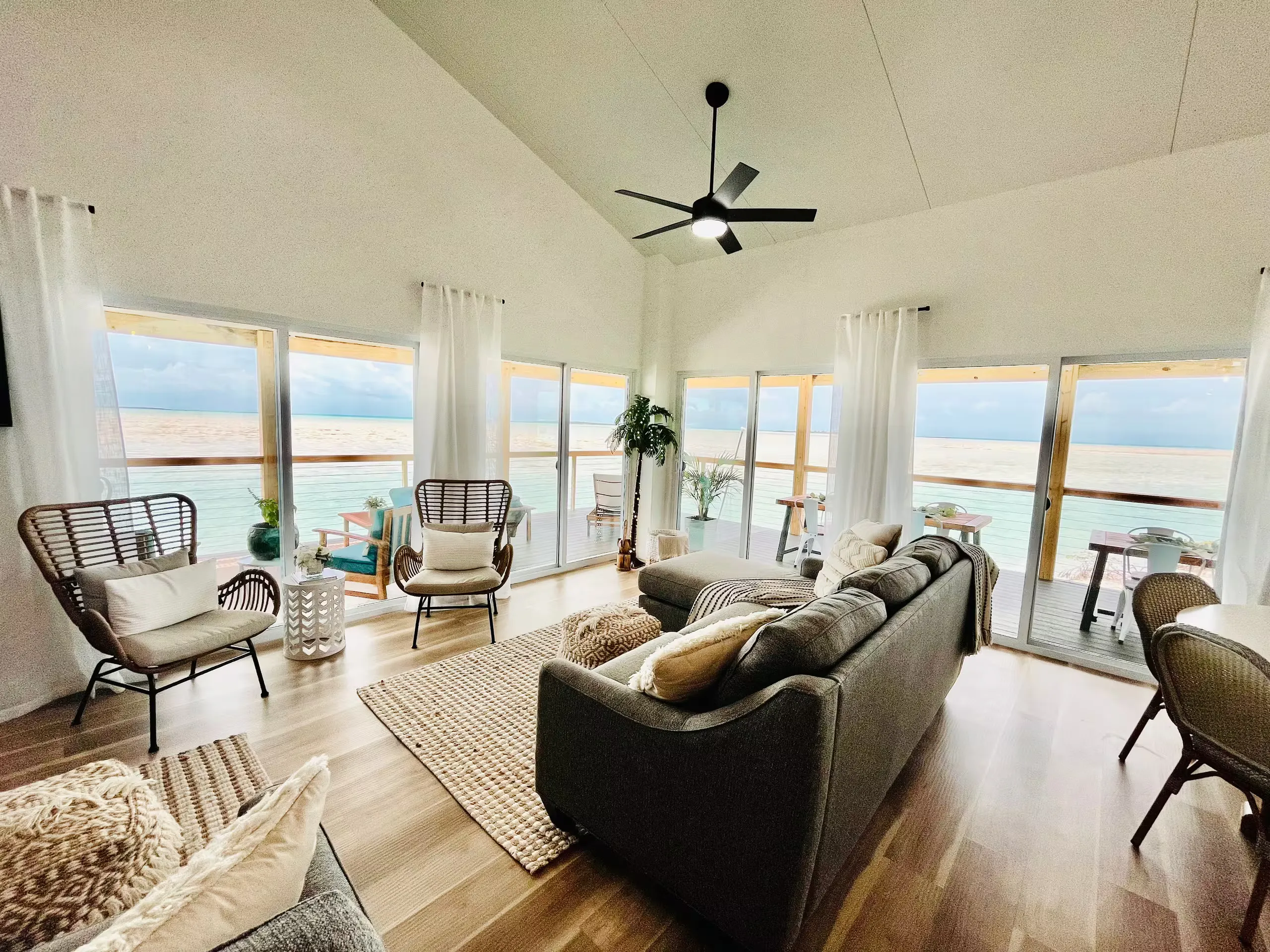 Living room wrapped in windows facing the water