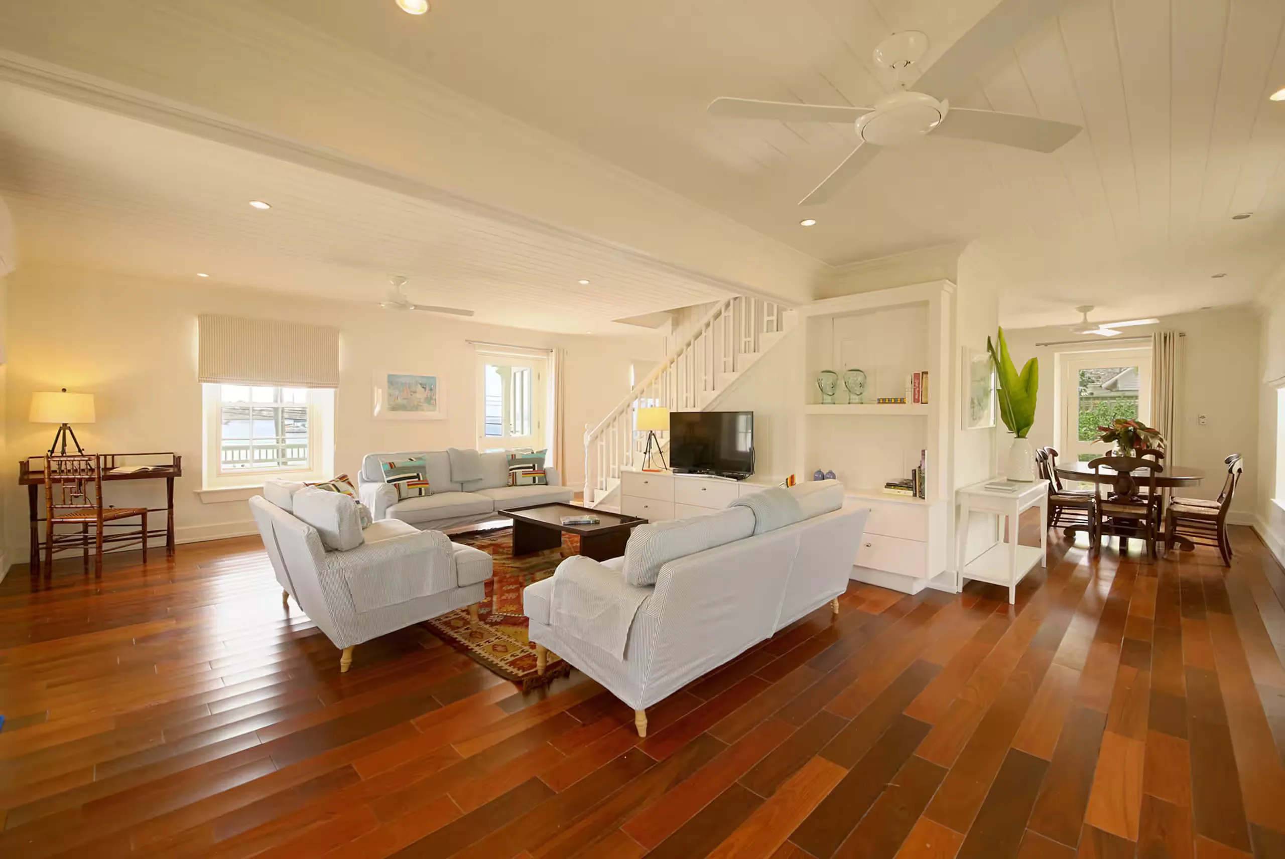 Living room with wood floors and a staircase to the second floor