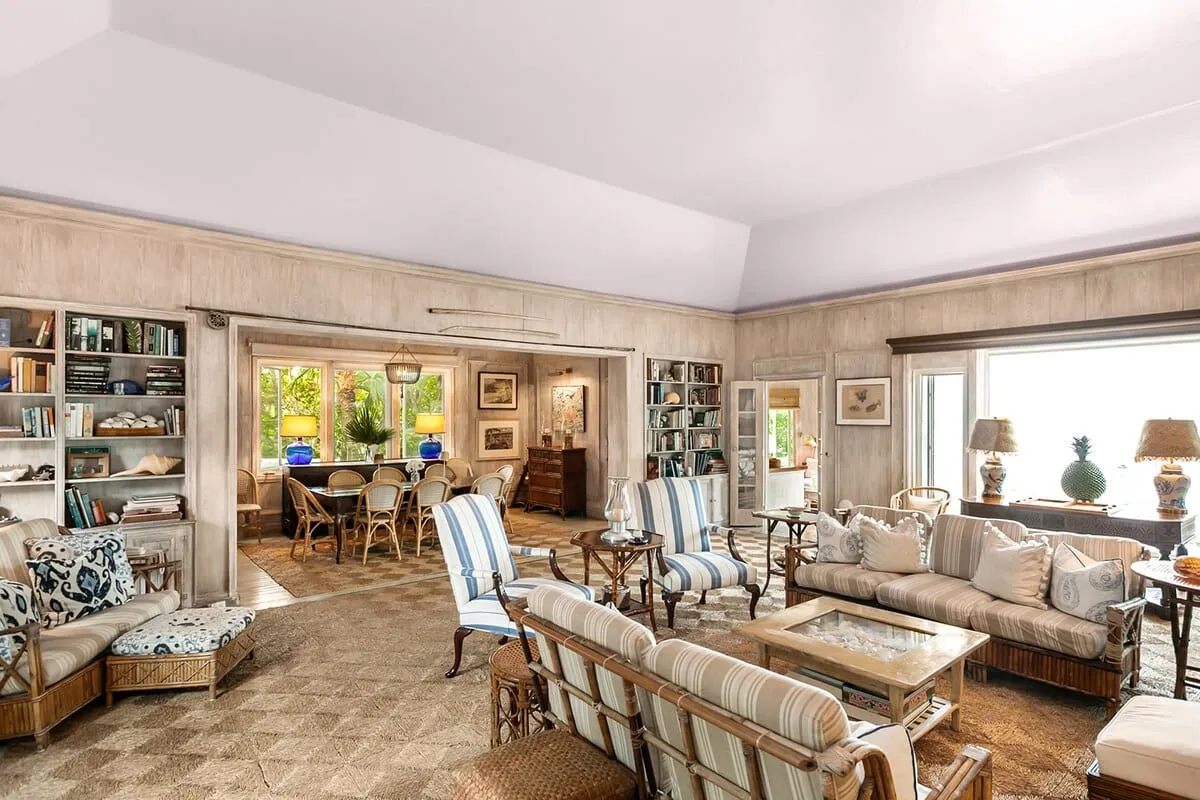 Coastal living room with rattan seating and vaulted wood-paneled walls