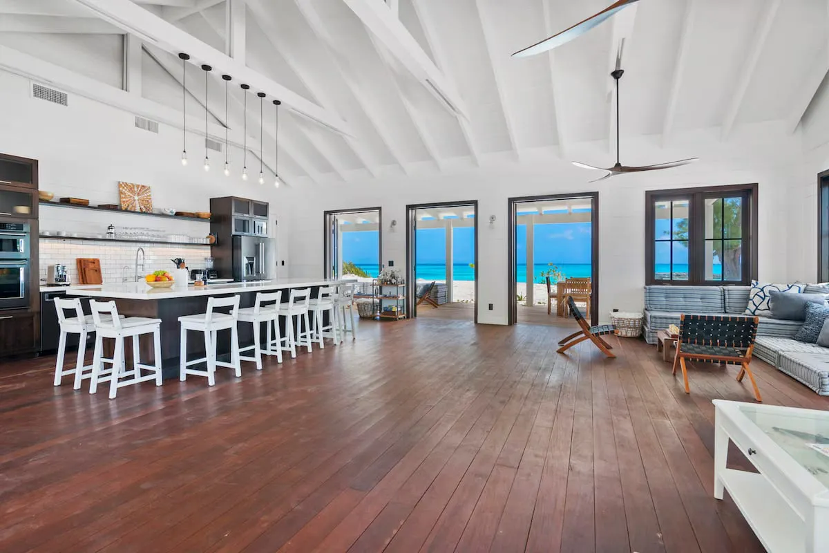 Open-plan kitchen and living room with ocean visible through glass doors