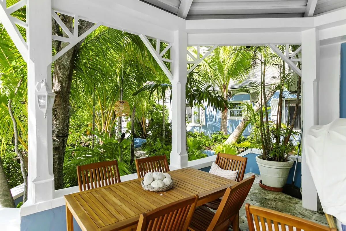 Outdoor dining table under a white gazebo beside the house