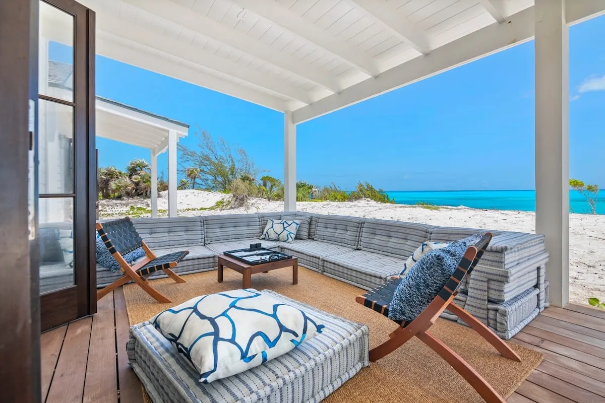 Porch seating with an open view of white sand and turquoise water