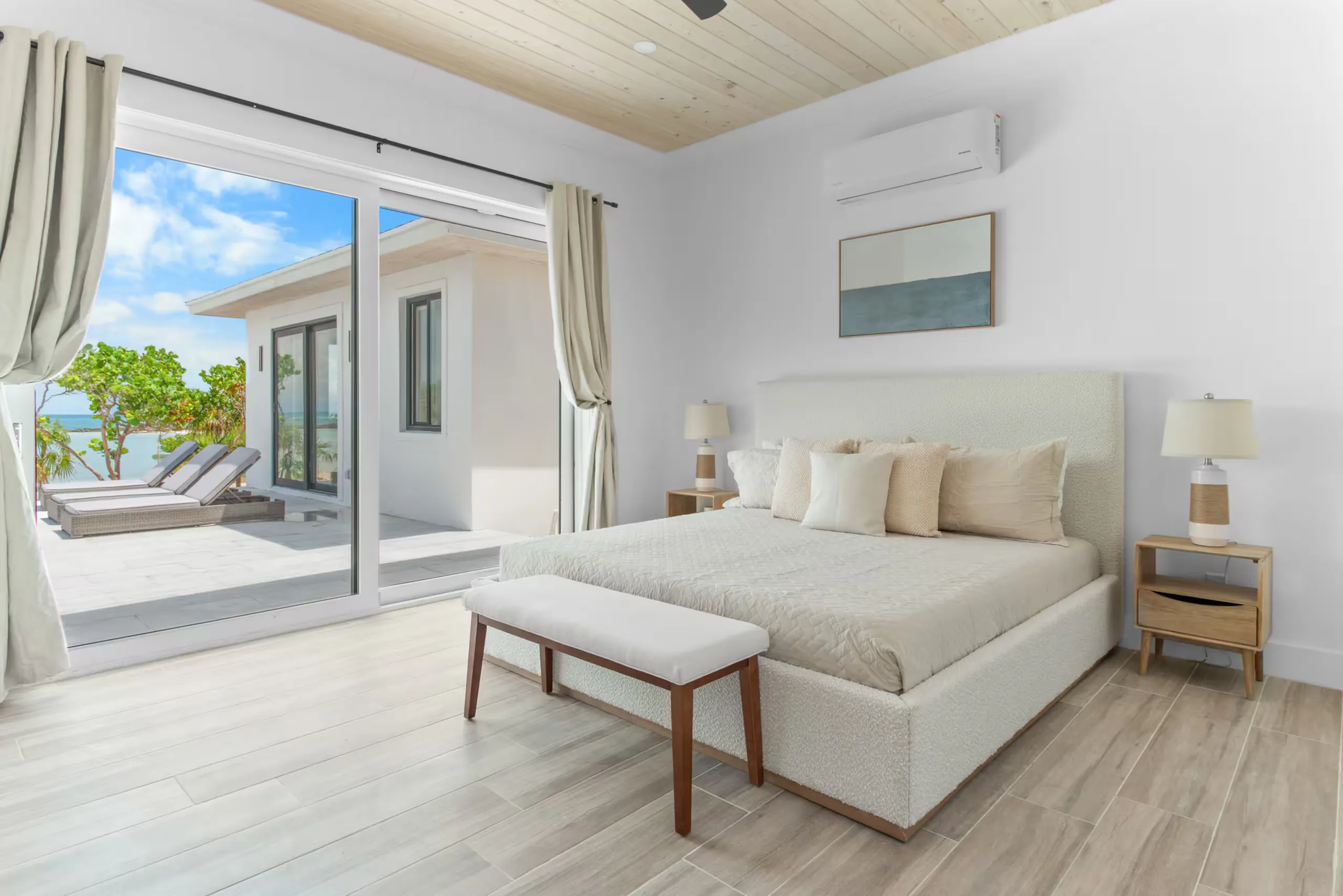 Primary bedroom with sliding doors onto the patio and ocean view
