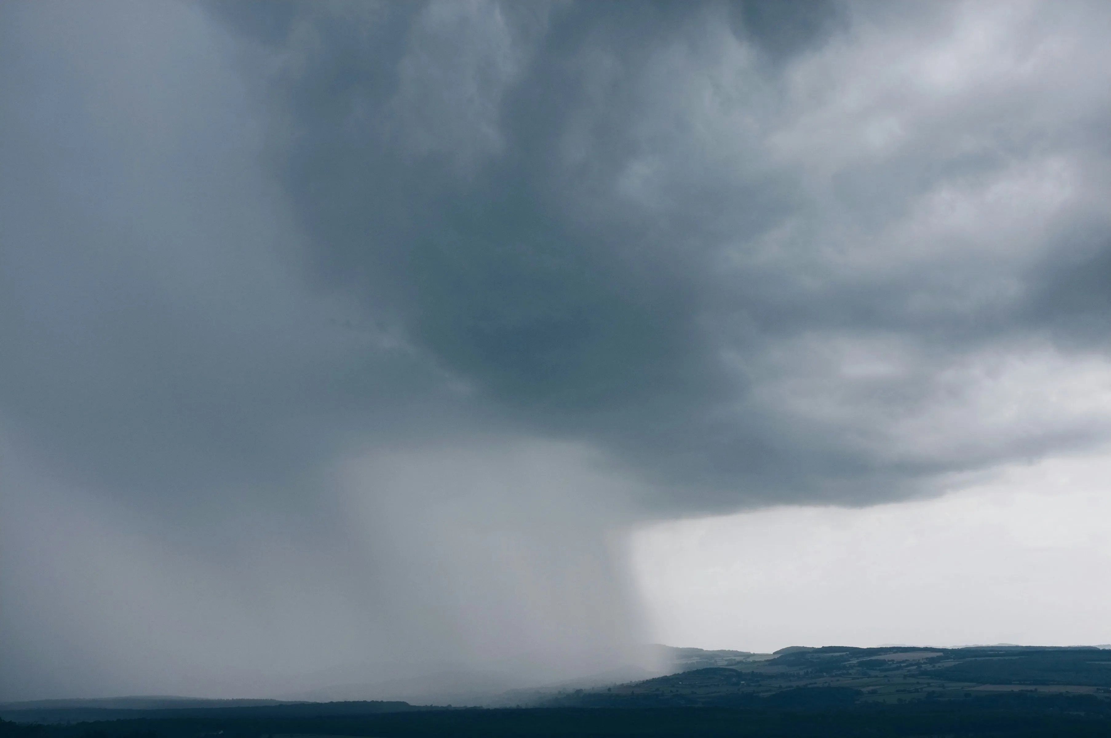 A heavy rain shaft dropping from a dark storm cell