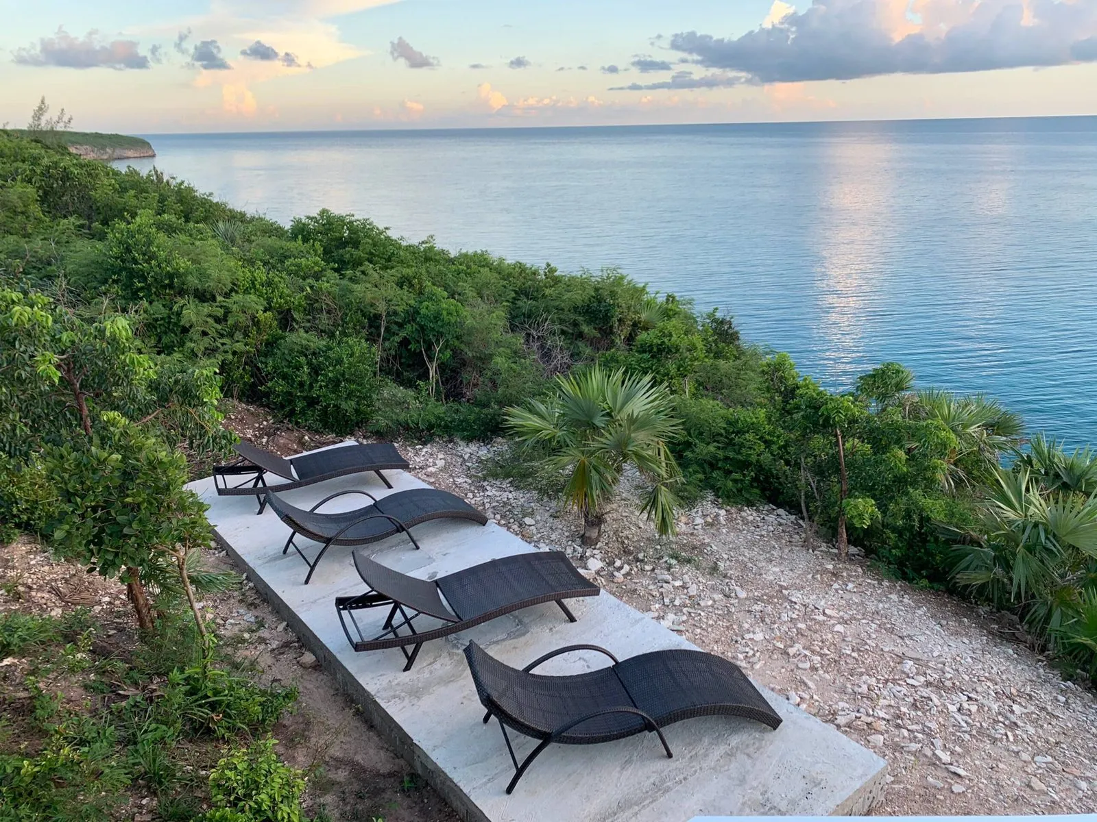 Loungers on the cliff edge at sunset