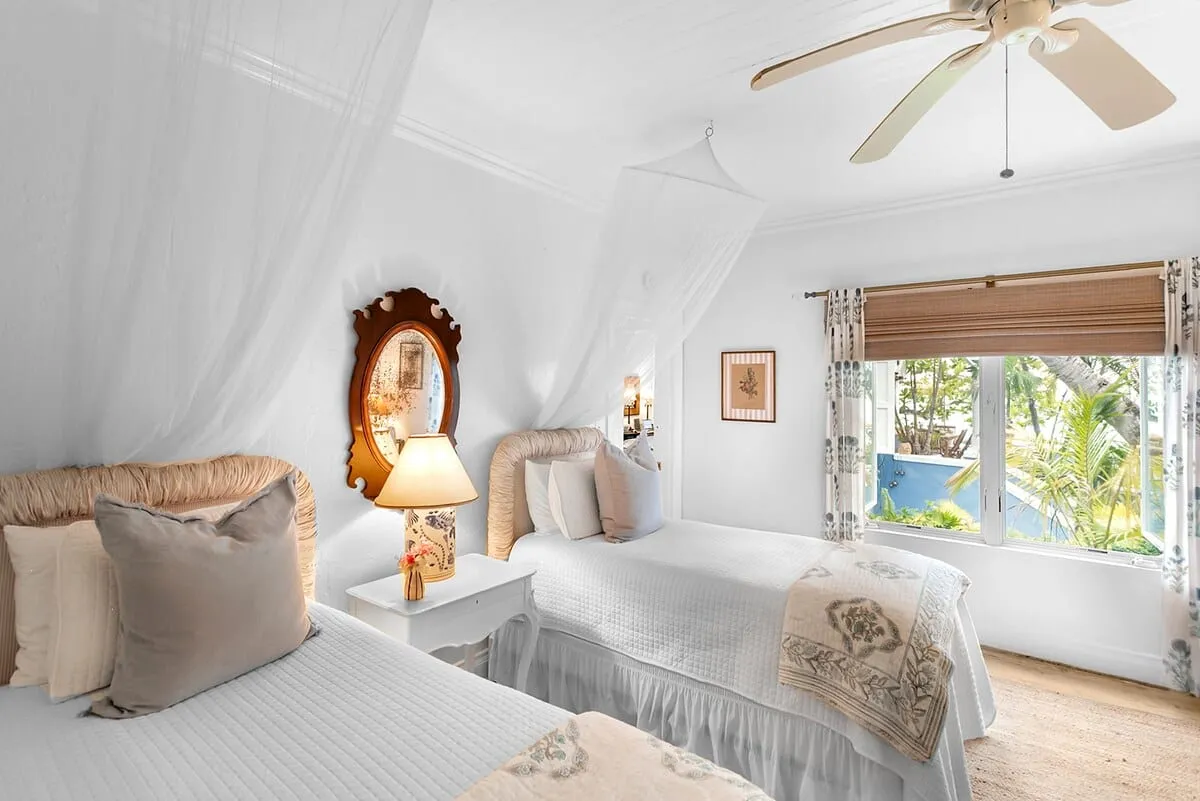 Twin bedroom with rattan headboards and sheer canopy nets